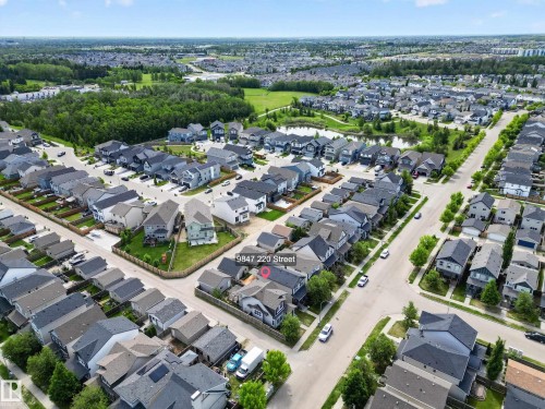 Aerial view of a residential neighborhood with green spaces and a pond - 9847 220 Street Nw, Edmonton, AB - Outdoor With View