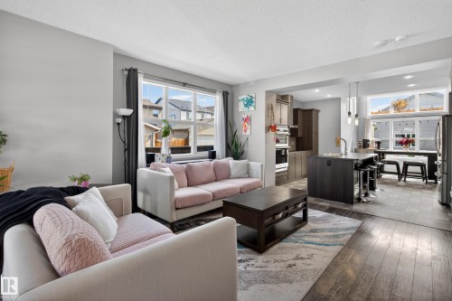 Open-concept living area featuring wood-finish flooring, recessed lighting, and large windows - 9847 220 Street Nw, Edmonton, AB - Indoor Photo Showing Living Room