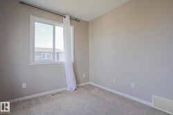 Neutral tone wall paint with white trim, carpeting, and a window with white casing - 