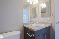 Vanity with integrated sink, chrome faucet, and dark wood-finish cabinetry - 