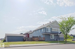Two-story residence featuring blue siding with light beige and white accents - 
