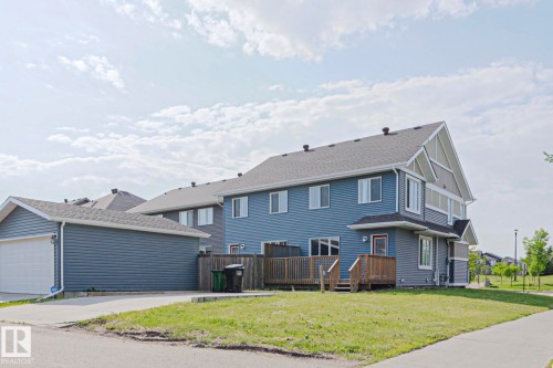 Exterior featuring blue horizontal siding and a dark shingle roof - 489 Orchards Boulevard Sw, Edmonton, AB - Outdoor