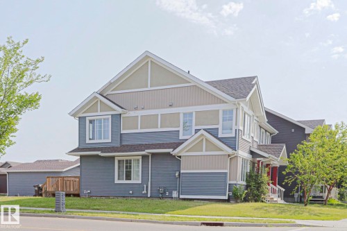Multi-level residence featuring a blue and tan siding exterior with white trim - 489 Orchards Boulevard Sw, Edmonton, AB - Outdoor With Facade