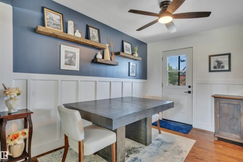 Board and batten wainscoting with a contrasting accent wall featuring reclaimed wood floating shelves - 5302 52 Ave, Wetaskiwin, AB - Indoor Photo Showing Dining Room