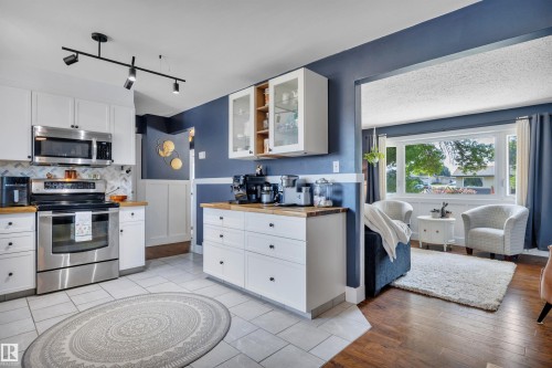 Kitchen with white cabinetry and wood-finish countertops - 5302 52 Ave, Wetaskiwin, AB - Indoor Photo Showing Kitchen
