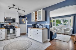 Kitchen with white cabinetry and wood-finish countertops - 