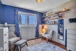 Room featuring wood-finish flooring, a window with exterior views, and board and batten wall detailing - 