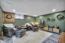 Spacious room featuring wood-finish flooring, a drop ceiling with recessed lighting, and a window with integrated lighting - 
