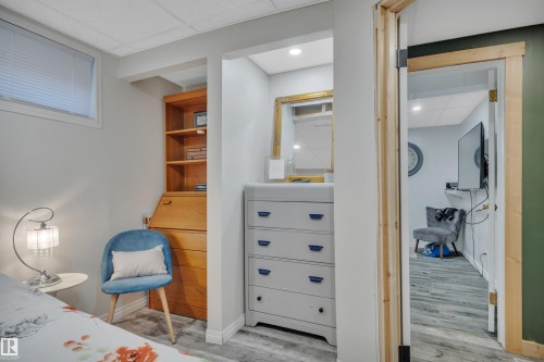 Lower-level room featuring light gray walls, a window with blinds, and wood-finish flooring - 5302 52 Ave, Wetaskiwin, AB - Indoor