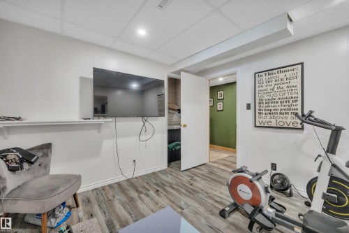 Versatile room featuring wood-finish flooring and a drop-panel ceiling with recessed lighting - 5302 52 Ave, Wetaskiwin, AB - Indoor