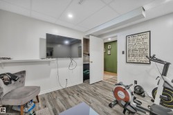 Versatile room featuring wood-finish flooring and a drop-panel ceiling with recessed lighting - 
