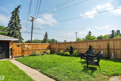 Fenced backyard featuring a manicured lawn, established landscaping, and a side access gate - 5302 52 Ave, Wetaskiwin, AB - Outdoor With Deck Patio Veranda