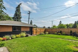 Expansive green lawn with a perimeter wood fence - 
