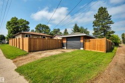 Detached garage with a dark sectional door, brick accents, and a shingled roof - 