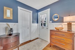 Entryway featuring hardwood flooring, white wainscoting, and a paneled door - 