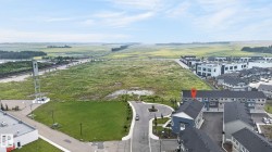 Aerial perspective showcasing the property's proximity to a large undeveloped field and newer residential developments - 