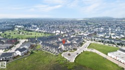 Aerial perspective showcasing a residential development with a mix of detached and attached homes - 