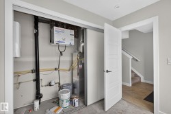 Utility closet with mechanical systems including a water heater and air exchanger - 