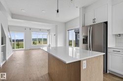 Kitchen island featuring a light-toned wood-finish base and a light-colored countertop - 