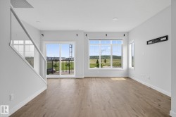 Spacious interior with wood-finish flooring, white walls, and recessed lighting - 