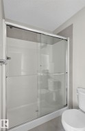 Shower enclosure featuring clear glass sliding doors and brushed chrome hardware - 