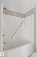 White tub and shower combination with a chrome showerhead and faucet - 
