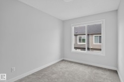 Neutral-toned interior room with light gray walls, white trim, gray carpet, and a white-framed window - 