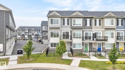 Contemporary multi-level townhome featuring a mix of horizontal siding and stone veneer accents - 