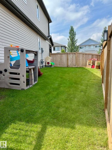 Expansive backyard featuring a manicured lawn, full wood fencing, and exterior wall lighting - 17359 49 Street Nw, Edmonton, AB - Outdoor