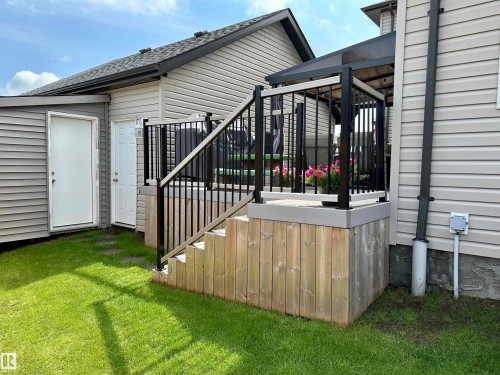 Outdoor deck featuring black aluminum railings, wood-finish stairs, and a partial privacy screen - 17359 49 Street Nw, Edmonton, AB - Outdoor With Exterior