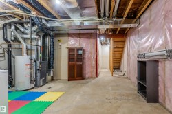 Unfinished basement space featuring exposed wood joists and concrete flooring - 