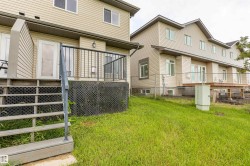 Rear exterior featuring a multi-level deck with black railings, a privacy wall, and a staircase - 