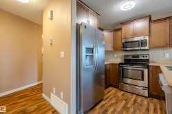 Kitchen featuring wood-finish flooring, stainless steel appliances, and wood cabinetry - 
