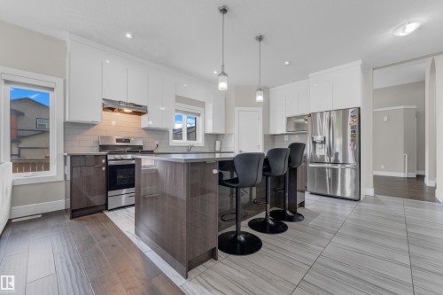 Modern kitchen with a central island featuring bar seating - 4506 49 Avenue, Beaumont, AB - Indoor Photo Showing Kitchen With Upgraded Kitchen