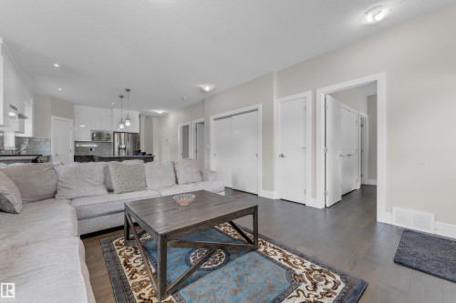 Open-concept living area with dark wood-finish flooring - 4506 49 Avenue, Beaumont, AB - Indoor Photo Showing Living Room
