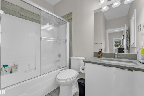 Bathroom featuring a white vanity with a gray countertop, an integrated sink, and chrome fixtures - 4506 49 Avenue, Beaumont, AB - Indoor Photo Showing Bathroom