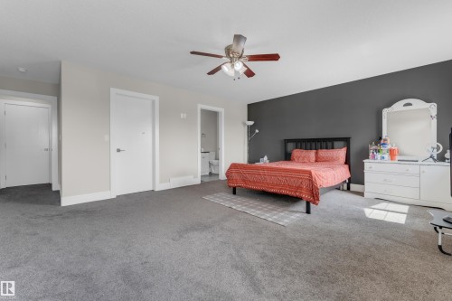 Spacious room featuring gray wall, light gray walls, gray carpeting, white trim, and a ceiling fan with integrated lighting - 4506 49 Avenue, Beaumont, AB - Indoor Photo Showing Bedroom