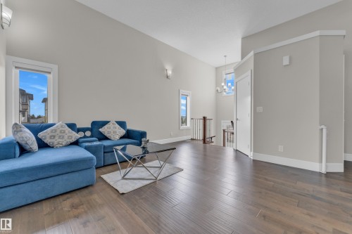 Spacious living area featuring wood-finish flooring, light grey walls, and white trim - 4506 49 Avenue, Beaumont, AB - Indoor Photo Showing Living Room