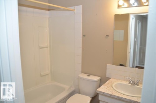 Bathroom featuring a white bathtub, a toilet, and a vanity with a drop-in sink - 14210 31 Street Nw, Edmonton, AB - Indoor Photo Showing Bathroom