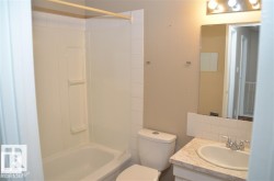 Bathroom featuring a white bathtub, a toilet, and a vanity with a drop-in sink - 