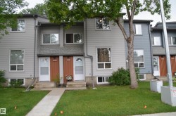 Two-story townhome exterior featuring light gray horizontal siding and a contrasting gray roof - 