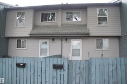 Exterior facade featuring light gray siding, white-framed windows, and a gray shingle roof - 
