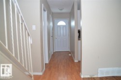 Entryway featuring wood-finish flooring, light neutral wall paint, and white trim - 