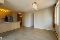 Kitchen with wood-finish cabinetry, stainless steel refrigerator, and breakfast bar - 