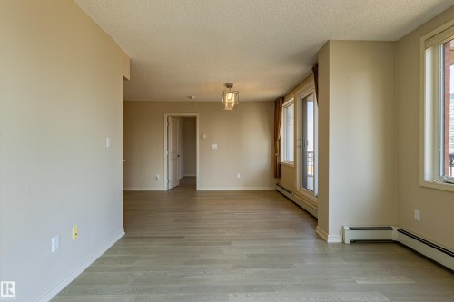 Spacious interior with neutral wall tones and wood-finish flooring - #1501 10180 104 St Nw, Edmonton, AB - Indoor Photo Showing Other Room