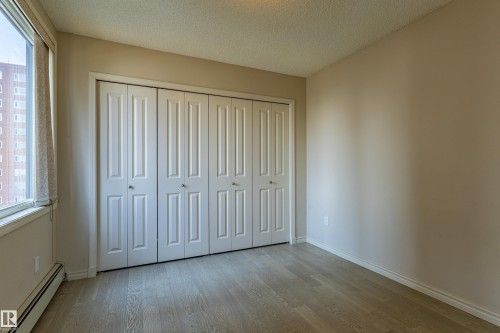 Expansive bi-fold closet system with six panel doors - #1501 10180 104 St Nw, Edmonton, AB - Indoor Photo Showing Other Room