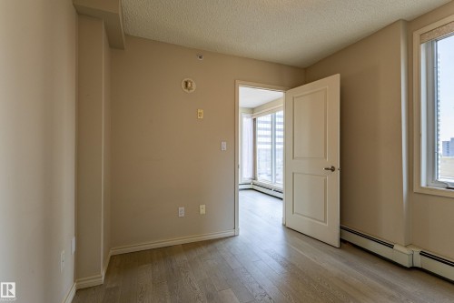 Interior space featuring wood-finish flooring, neutral wall tones, and white trim - #1501 10180 104 St Nw, Edmonton, AB - Indoor Photo Showing Other Room