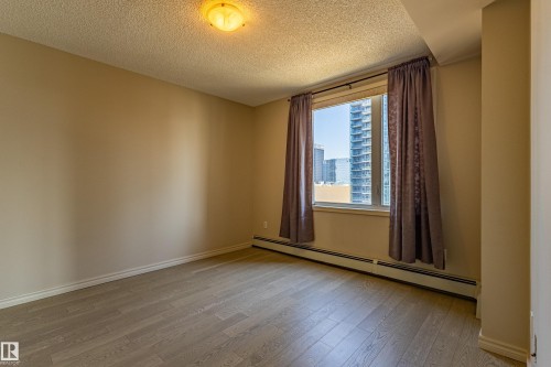 Bright room with a large window and light wood-finish flooring - #1501 10180 104 St Nw, Edmonton, AB - Indoor Photo Showing Other Room