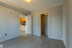 Room featuring light gray wood-finish flooring, neutral painted walls, and white trim - 
