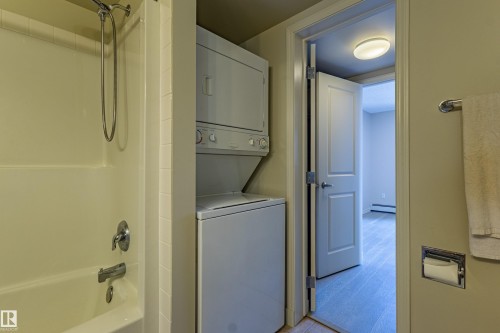 Tub/shower combination with chrome fixtures - #1501 10180 104 St Nw, Edmonton, AB - Indoor Photo Showing Laundry Room